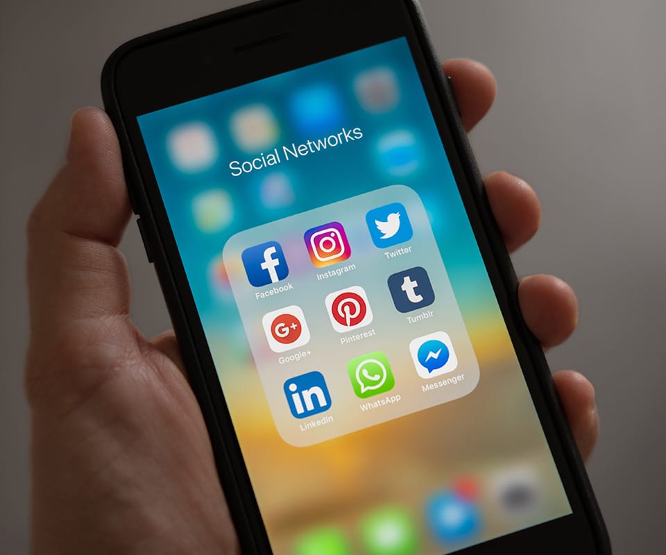 An iPhone with social media icons on the screen